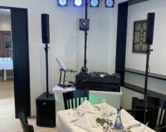 DJ-Equipment mit Lautsprechern und Lichtanlage in elegantem Restaurantraum mit weiß gedecktem Tisch für Hochzeit