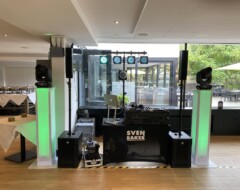 DJ-Setup von Sven Baker mit beleuchteten Säulen, Mischpult und Lichtanlage in modernem Veranstaltungsraum